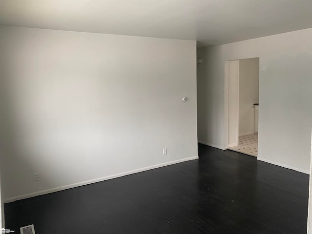 spare room featuring dark wood-type flooring