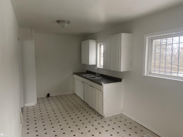 5509 Farmhill Rd, Flint, MI 48505 - laundry room featuring a sink, light floors, and baseboards