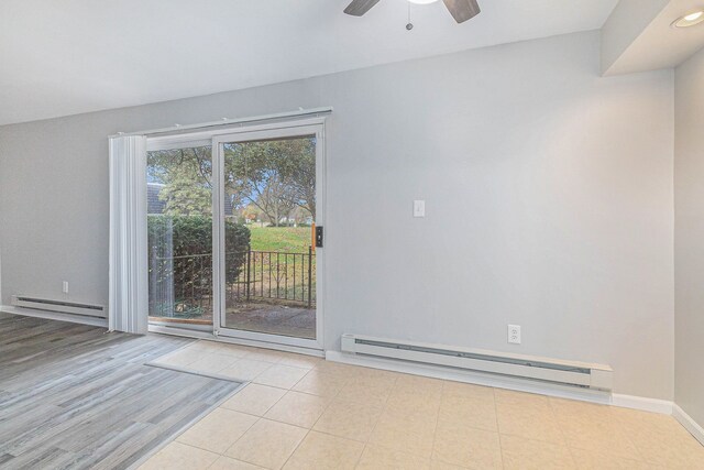 spare room with a wealth of natural light, a baseboard radiator, and light wood-type flooring