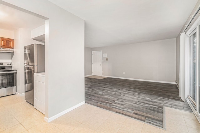 kitchen with washer / dryer, light hardwood / wood-style flooring, and appliances with stainless steel finishes