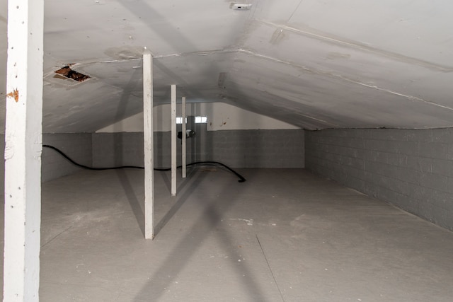 additional living space with concrete flooring and lofted ceiling