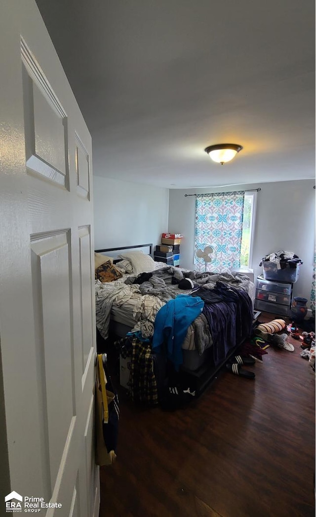 bedroom with dark hardwood / wood-style flooring