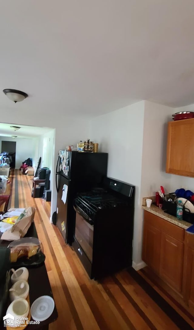 kitchen with black gas stove and dark hardwood / wood-style floors