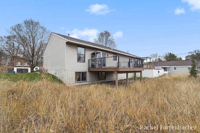 rear view of house featuring a wooden deck