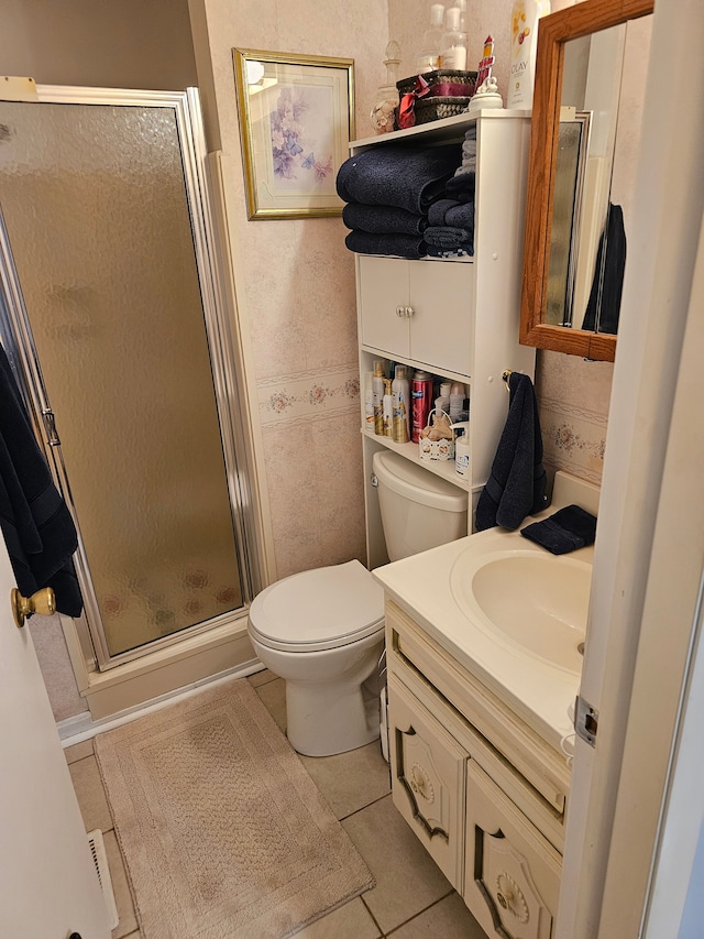 bathroom with tile patterned floors, vanity, toilet, and walk in shower