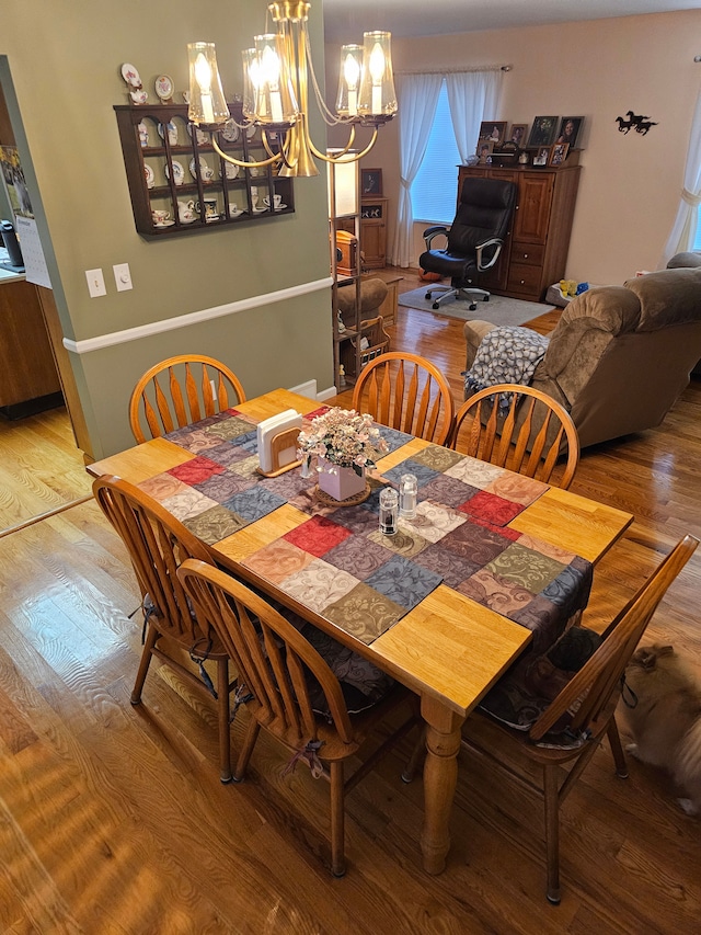 dining space featuring a notable chandelier and wood-type flooring