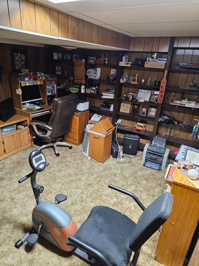 carpeted office featuring wood walls