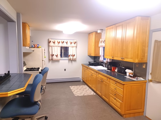 kitchen with tile countertops, white fridge, sink, and a baseboard heating unit