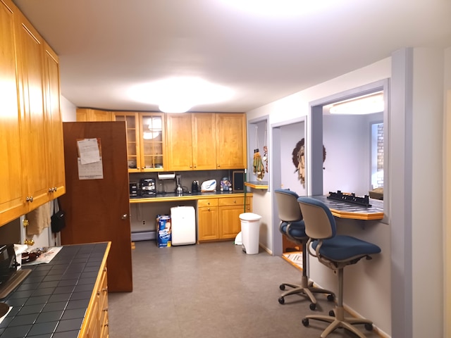 kitchen featuring tile countertops and a baseboard heating unit