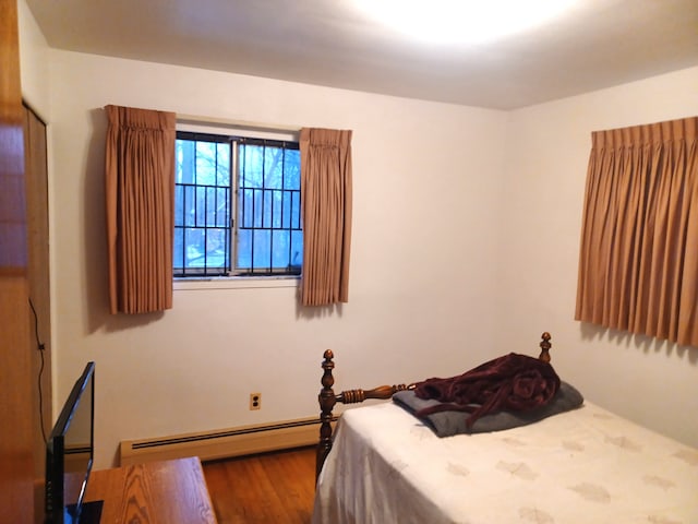 bedroom featuring hardwood / wood-style flooring and a baseboard radiator