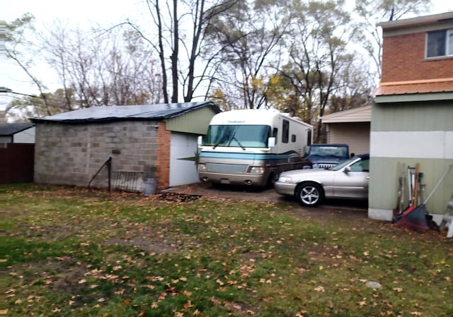 view of yard with a garage and an outbuilding