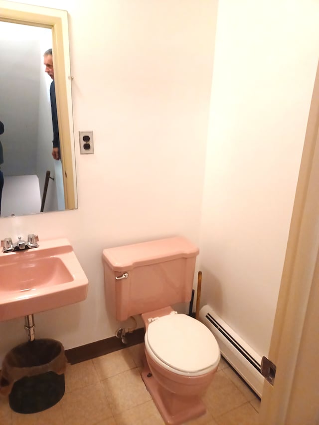 bathroom featuring tile patterned floors, toilet, sink, and a baseboard heating unit