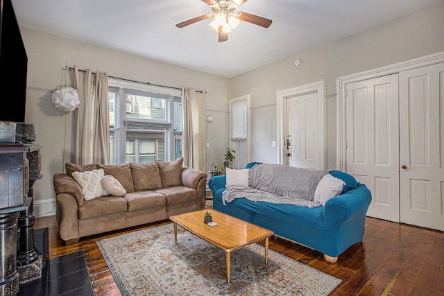 living room with dark wood-type flooring and ceiling fan