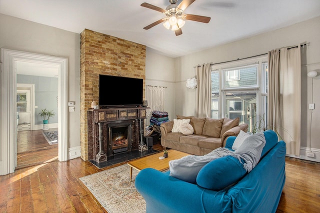 living room with ceiling fan, lofted ceiling, dark hardwood / wood-style flooring, and a brick fireplace