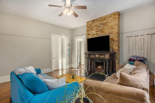 living room featuring hardwood / wood-style flooring, a brick fireplace, and ceiling fan