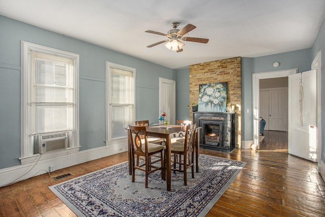 dining area with ceiling fan, cooling unit, a fireplace, and dark hardwood / wood-style flooring