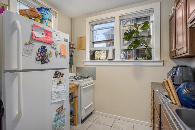 kitchen with light tile patterned floors and white appliances