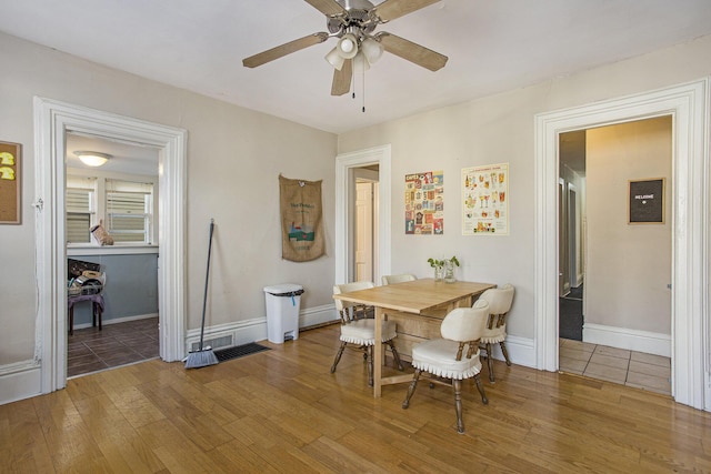 dining area with wood-type flooring and ceiling fan