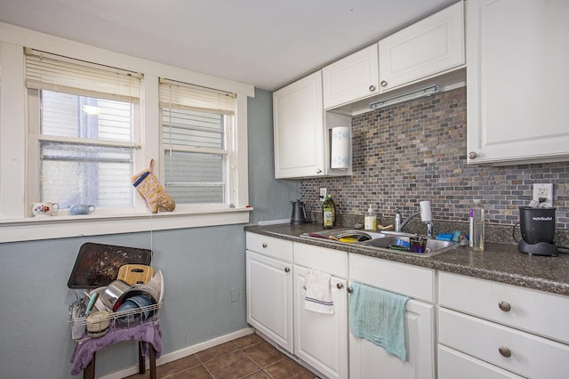 kitchen featuring backsplash, sink, and white cabinets