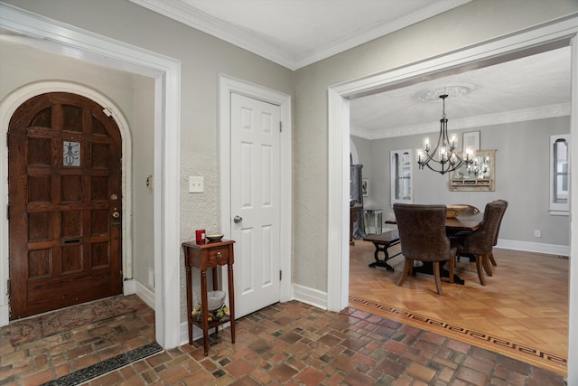 foyer entrance featuring crown molding and a chandelier