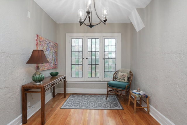 sitting room featuring hardwood / wood-style floors and a chandelier