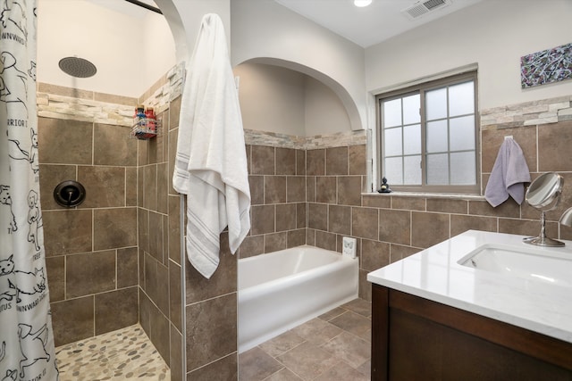 bathroom featuring vanity, shower with separate bathtub, and tile walls