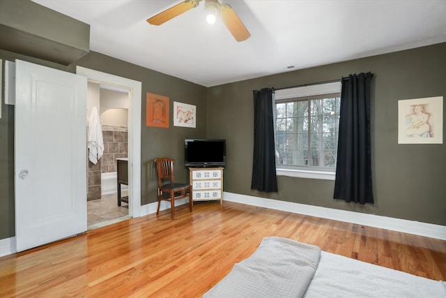 bedroom with connected bathroom, hardwood / wood-style flooring, and ceiling fan