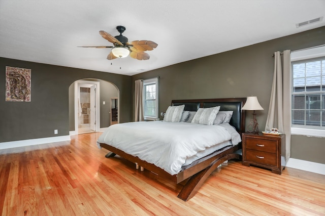 bedroom featuring ceiling fan, light wood-type flooring, and multiple windows