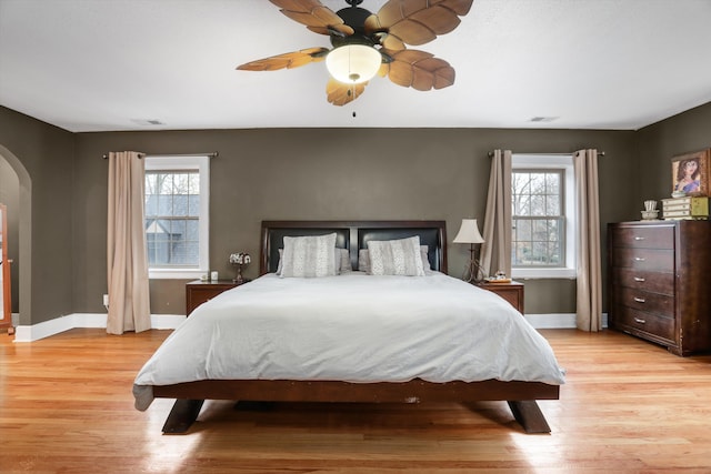 bedroom with multiple windows, ceiling fan, and light hardwood / wood-style floors