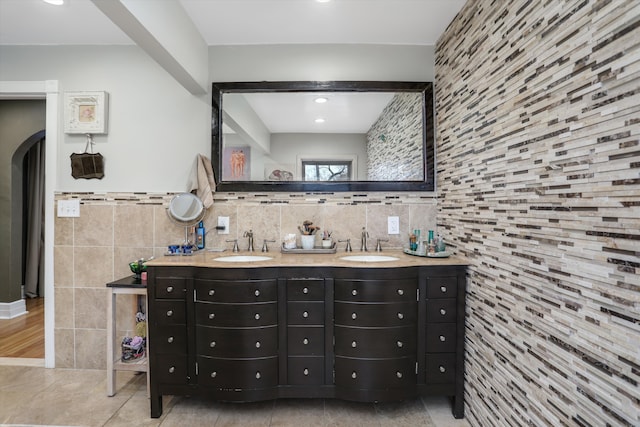 bathroom featuring beamed ceiling, vanity, and tile walls