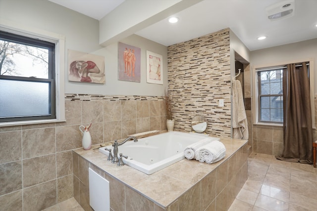 bathroom with tile walls and tiled tub