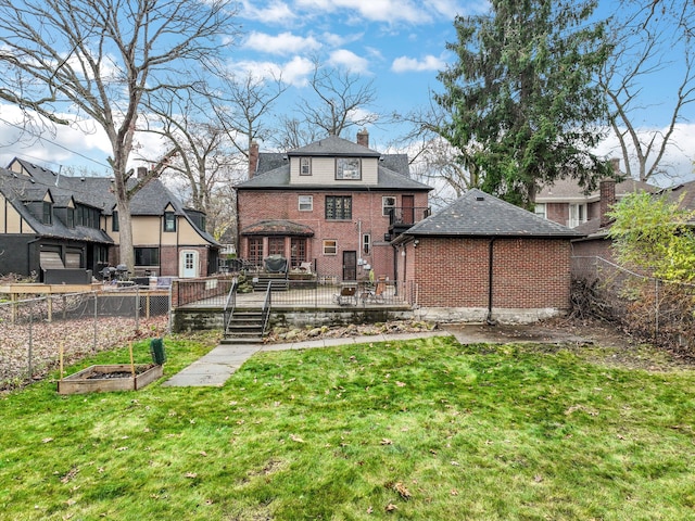 rear view of property featuring a wooden deck and a lawn