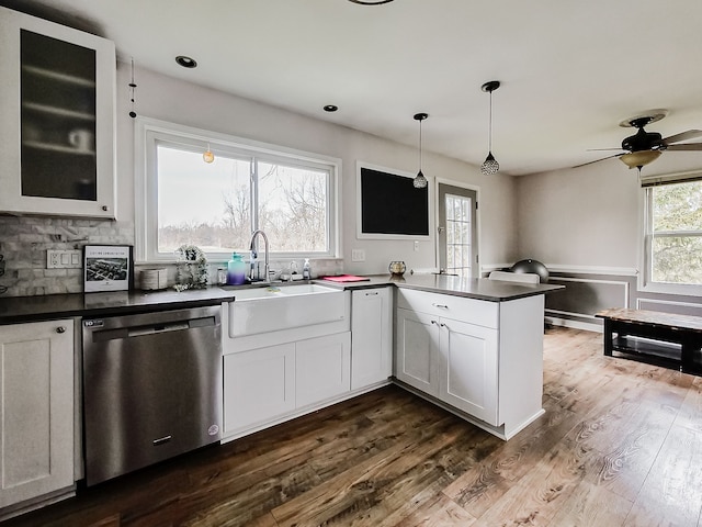 kitchen featuring kitchen peninsula, white cabinets, dark wood-type flooring, pendant lighting, and dishwasher