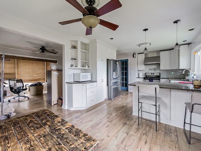 kitchen with sink, pendant lighting, light hardwood / wood-style floors, white cabinets, and appliances with stainless steel finishes