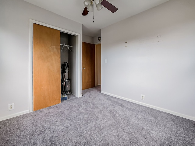 unfurnished bedroom with carpet, a closet, and ceiling fan