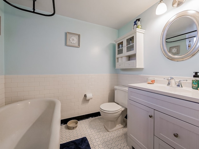 bathroom featuring tile patterned flooring, vanity, tile walls, and toilet