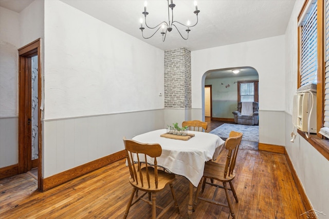 dining room with hardwood / wood-style floors and an inviting chandelier