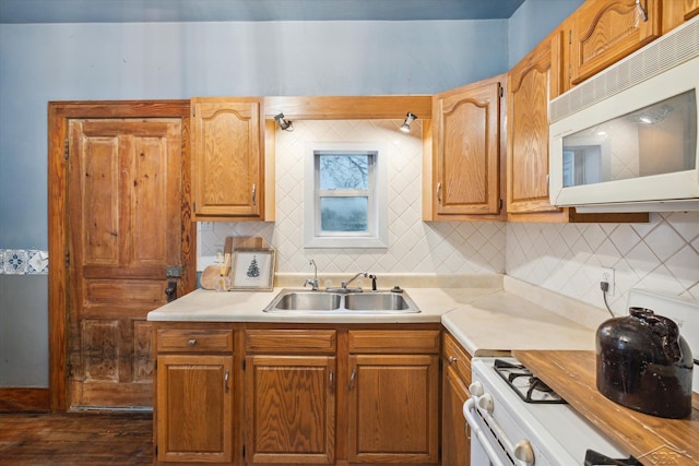 kitchen with white appliances, dark hardwood / wood-style floors, backsplash, and sink