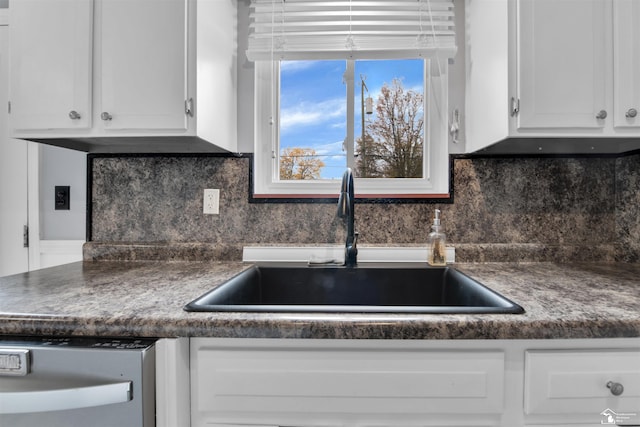 kitchen featuring backsplash, white cabinetry, and sink