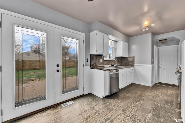 kitchen featuring backsplash, french doors, white cabinets, stainless steel dishwasher, and wood-type flooring