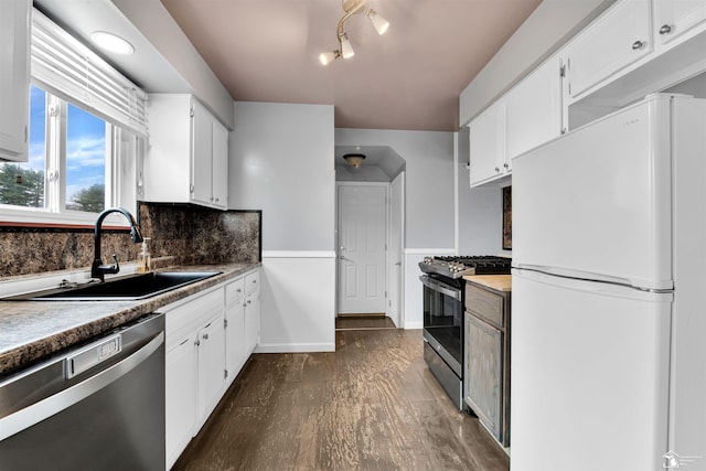 kitchen featuring decorative backsplash, appliances with stainless steel finishes, dark wood-type flooring, sink, and white cabinets