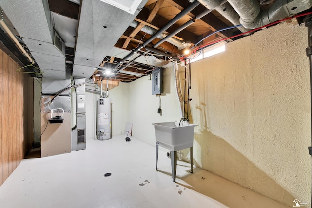 basement with electric panel, heating unit, wood walls, and water heater