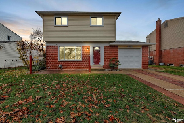 front of property with a garage and a yard