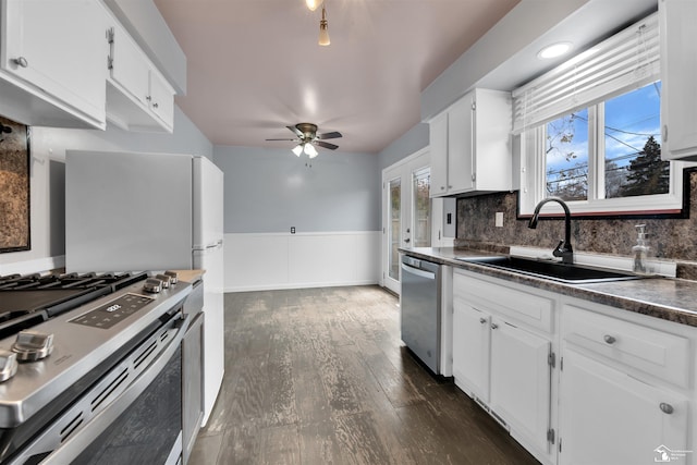 kitchen featuring white cabinets, sink, decorative backsplash, appliances with stainless steel finishes, and dark hardwood / wood-style flooring