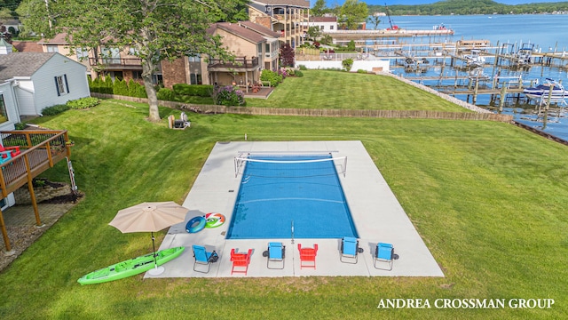 view of pool featuring a patio area, a yard, a water view, and a boat dock