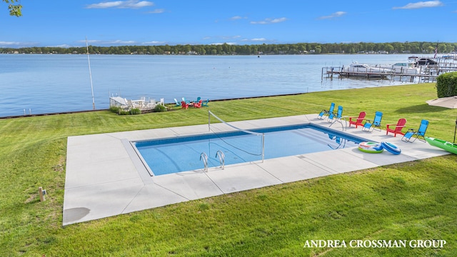 view of swimming pool featuring a patio area, a yard, and a water view