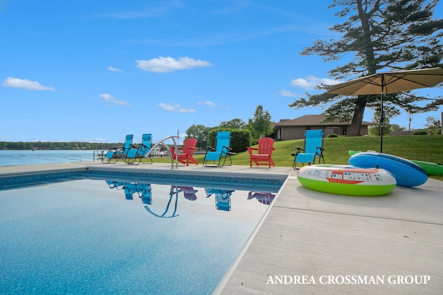 view of swimming pool featuring a lawn and a water view