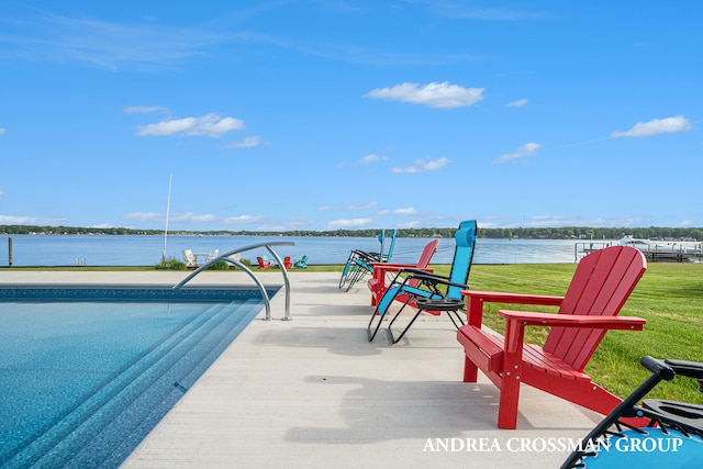 view of swimming pool with a yard and a water view