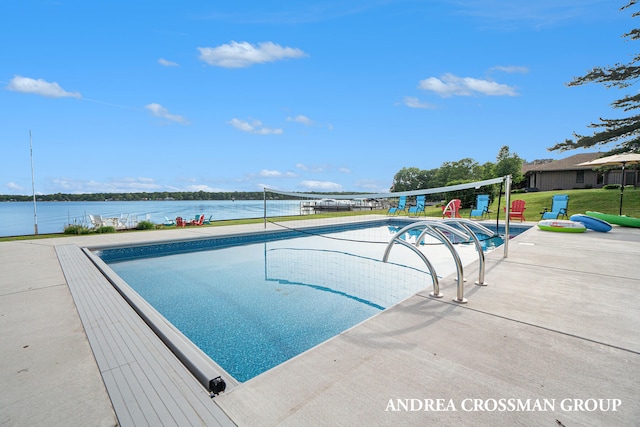 view of swimming pool with a lawn and a water view