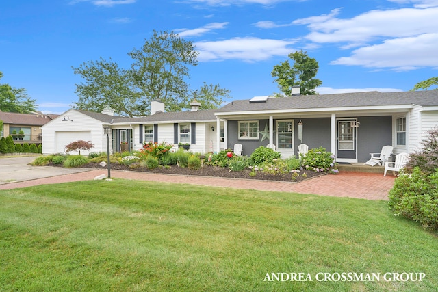 ranch-style house featuring a front lawn, covered porch, and a garage